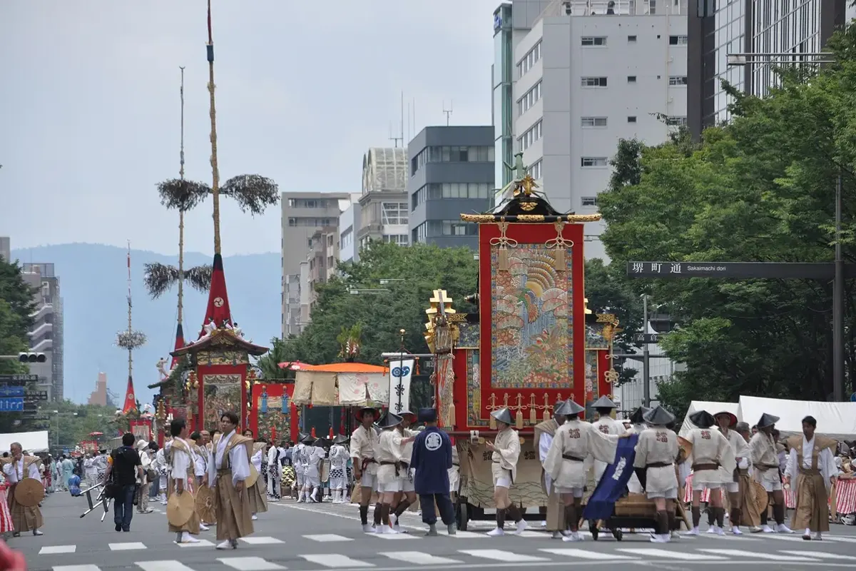 A tall yamahoko float being pulled through the street at Gion Matsuri in Kyoto