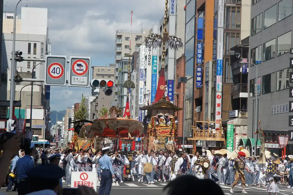 Crowds beside a lantern-hung Gion Matsuri float in central Kyoto