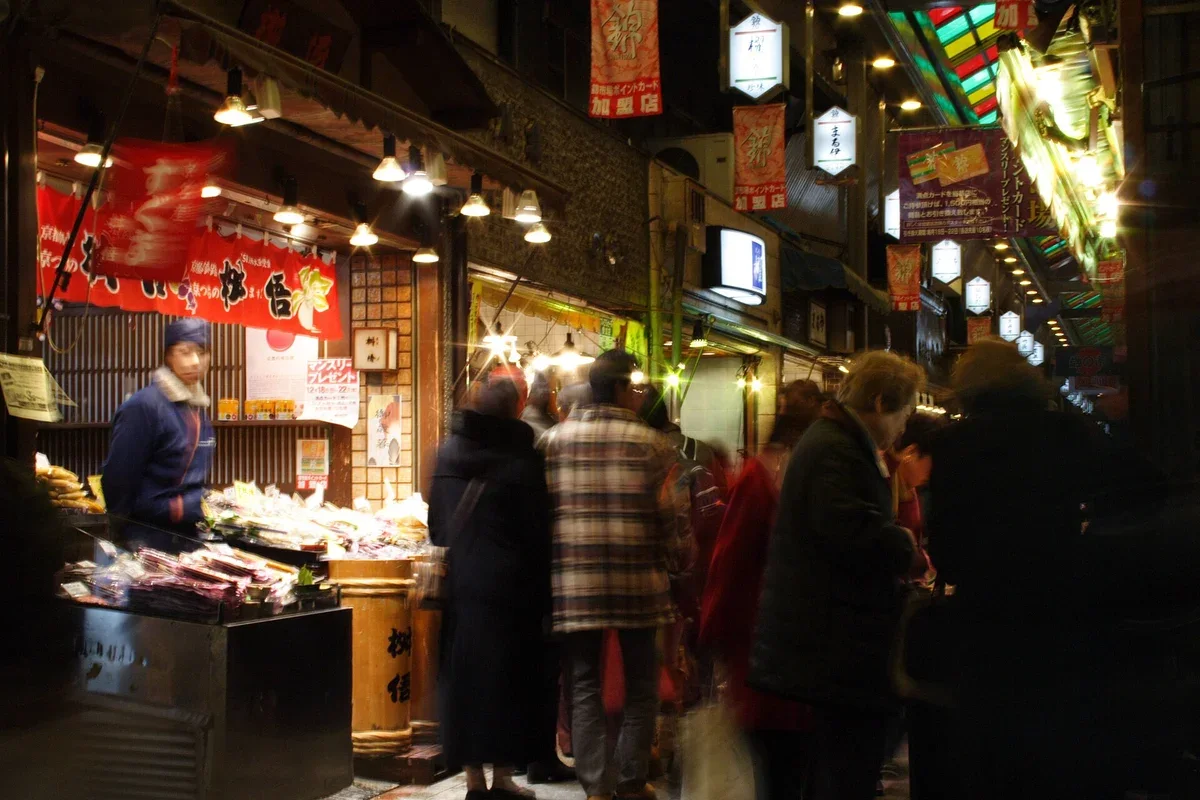 Stalls and shoppers under the arcade roof of Nishiki Market in Kyoto