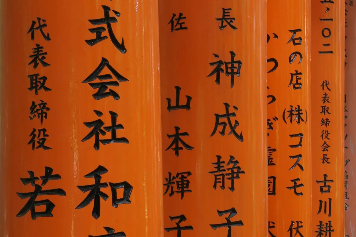 Donors' names inscribed in black on the back of a torii gate at Fushimi Inari
